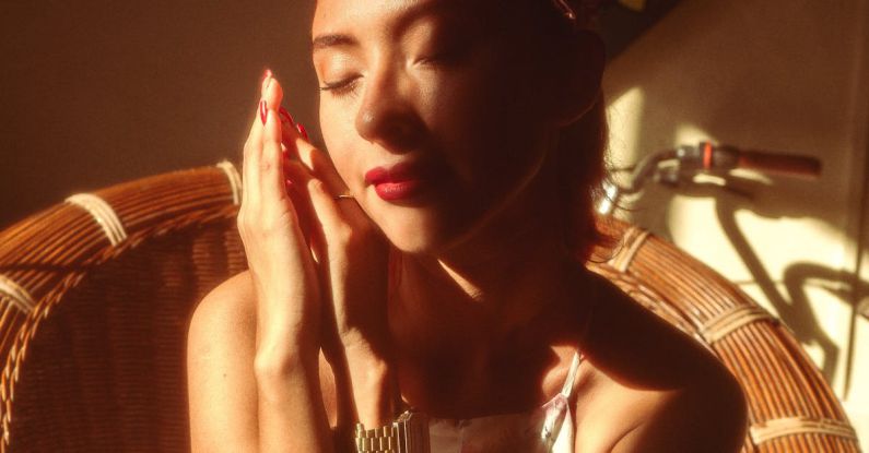 Meditation Beauty - Woman Sitting on a Rattan Armchair, in a Light and Shadow