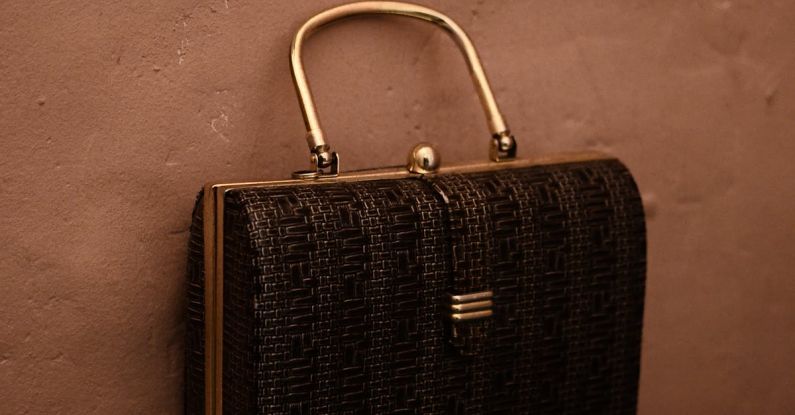 Handbags Trends - Vintage bag with golden handle placed on reflecting surface as accessory for garment