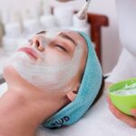 Face Mask Beauty - woman lying on blue towel with white cream on face