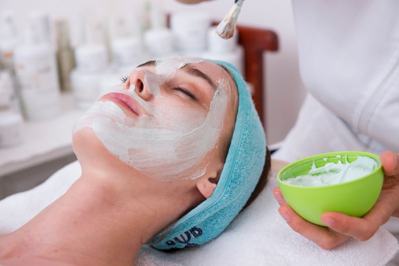 Face Mask Beauty - woman lying on blue towel with white cream on face