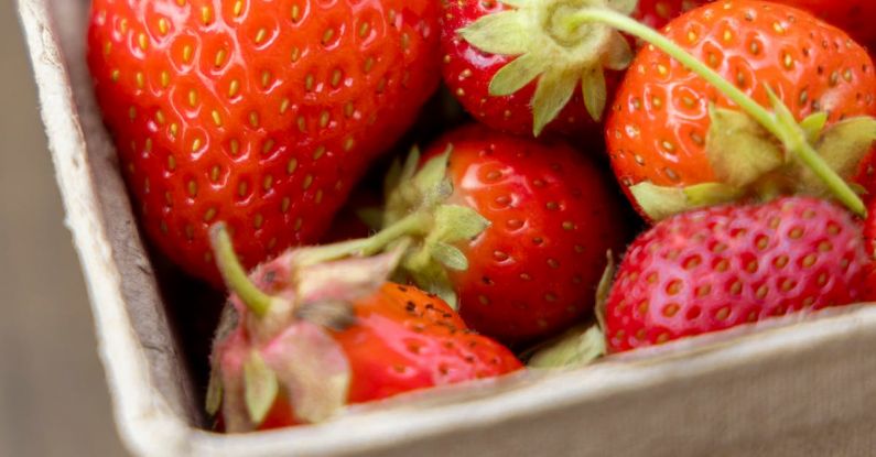 Healthy Scalp - A box of strawberries on a wooden table