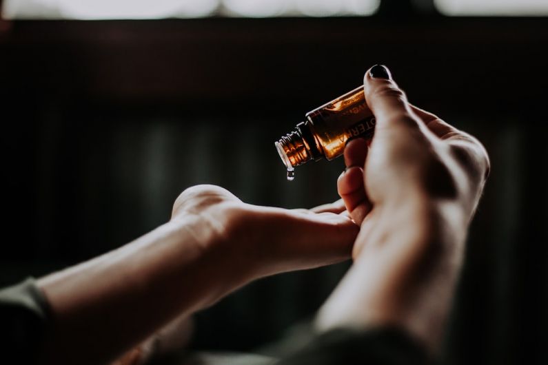 Natural Oils - person holding amber glass bottle