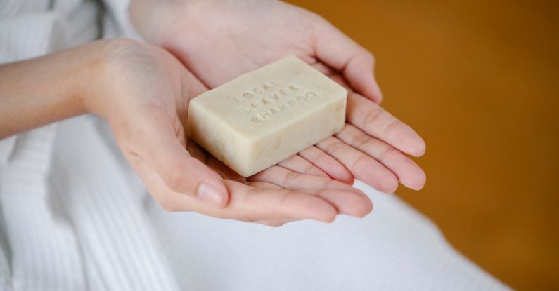 Dry Shampoo - Crop anonymous female showing rectangular shaped dry ecological shampoo with title on blurred background