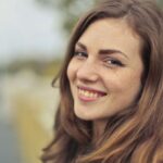 Natural Face - Shallow Focus Photo of a Woman in Blue Sleeveless Top