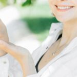 Green Tea Skincare - Smiling Woman in White Dress Shirt Holding Black Smartphone