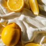 Chemical Peel - From above of bright cut and whole juicy lemons on creased bed sheet in house in sunlight