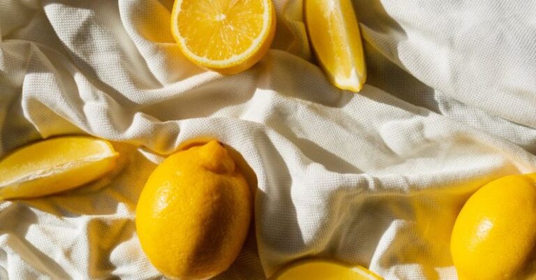 Chemical Peel - From above of bright cut and whole juicy lemons on creased bed sheet in house in sunlight