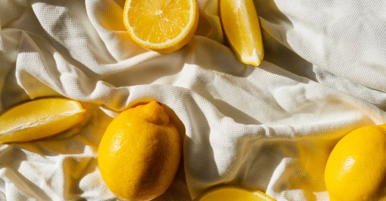 Chemical Peel - From above of bright cut and whole juicy lemons on creased bed sheet in house in sunlight