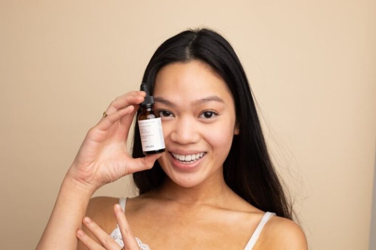 Vegan Skincare - woman in white tank top holding white labeled bottle